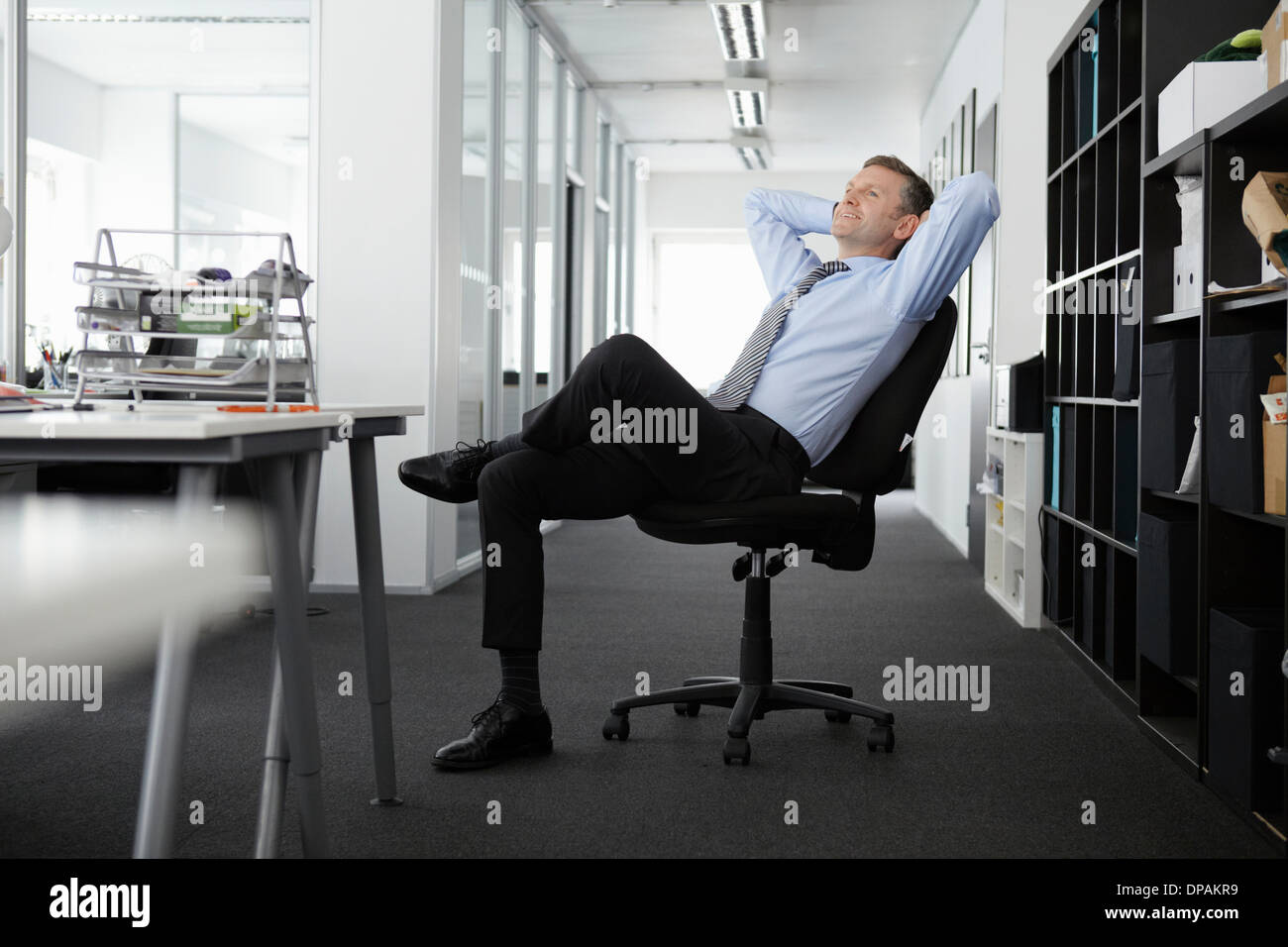 Leaning back in his chair hi-res stock photography and images - Alamy