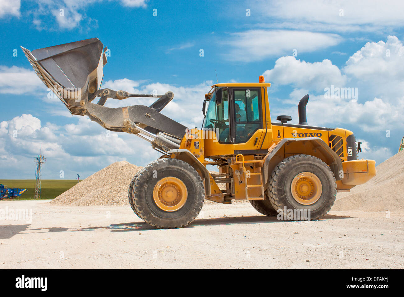 Yellow excavator on a construction site against blue sky Stock Photo ...