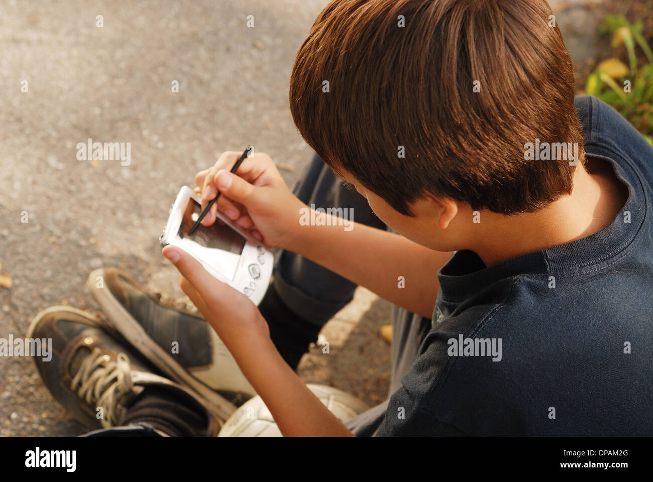 Boy playing with a gadget Stock Photo