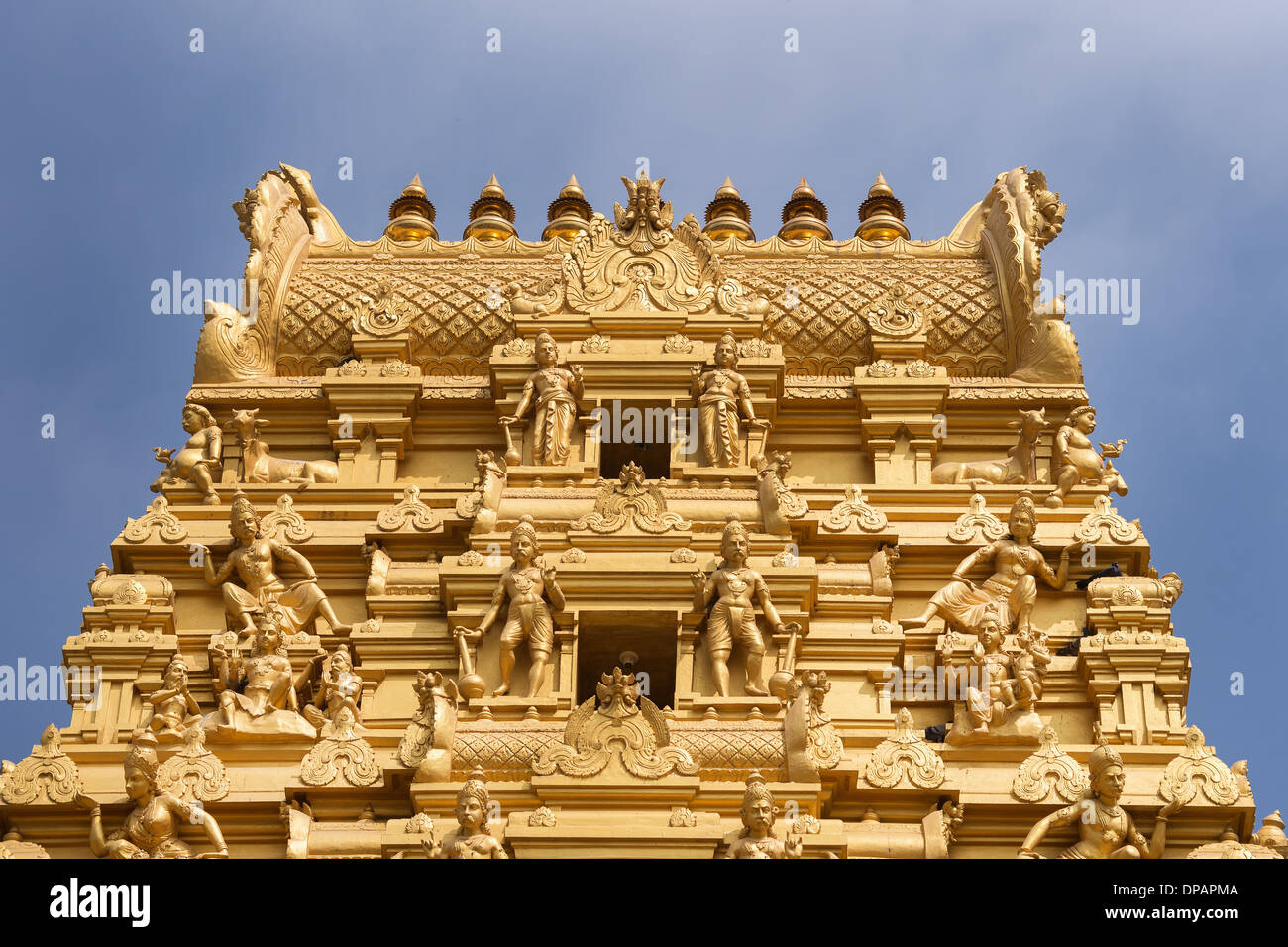 Plenty of golden statues on the top of the entrance tower at Sri Naheshwara in Bengaluru. Stock Photo