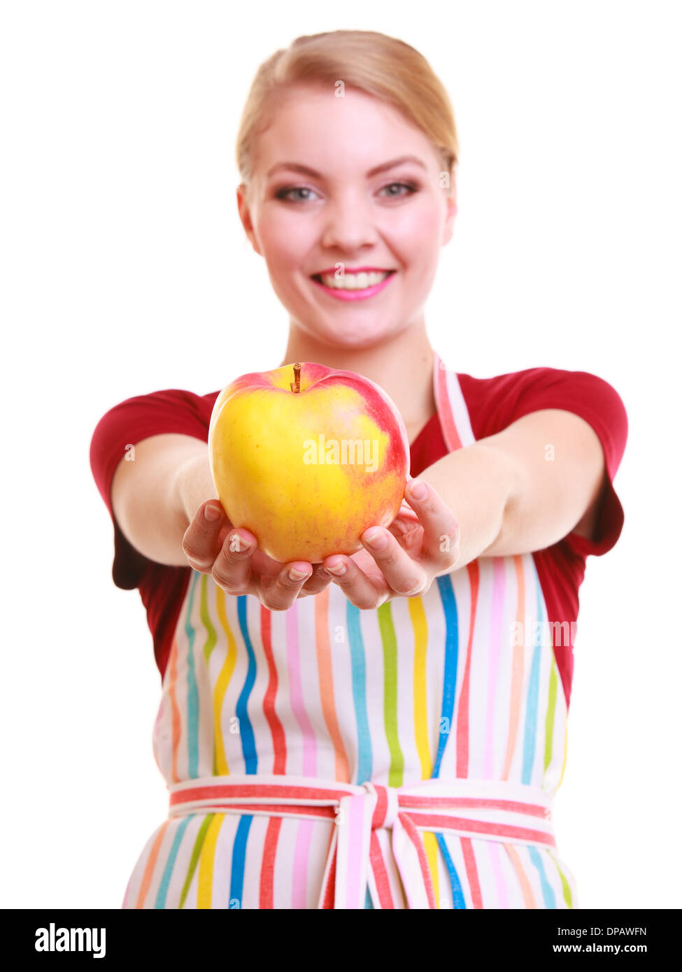 Happy housewife or chef in colorful kitchen showing red yellow apple healthy fruit isolated studio shot. Diet and nutrition. Stock Photo