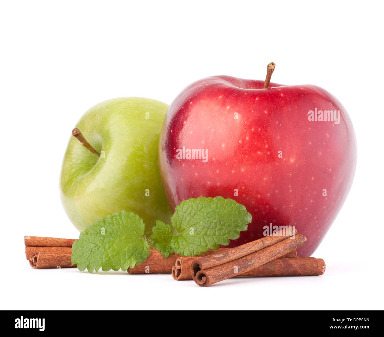 Red and green apples, cinnamon sticks and mint leaves still life isolated on white cutout Stock Photo