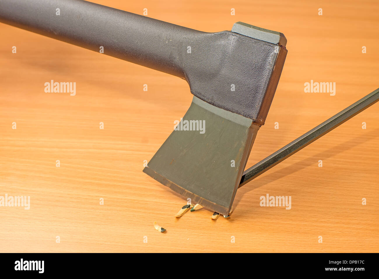 Sharpening a pencil with an axe Stock Photo