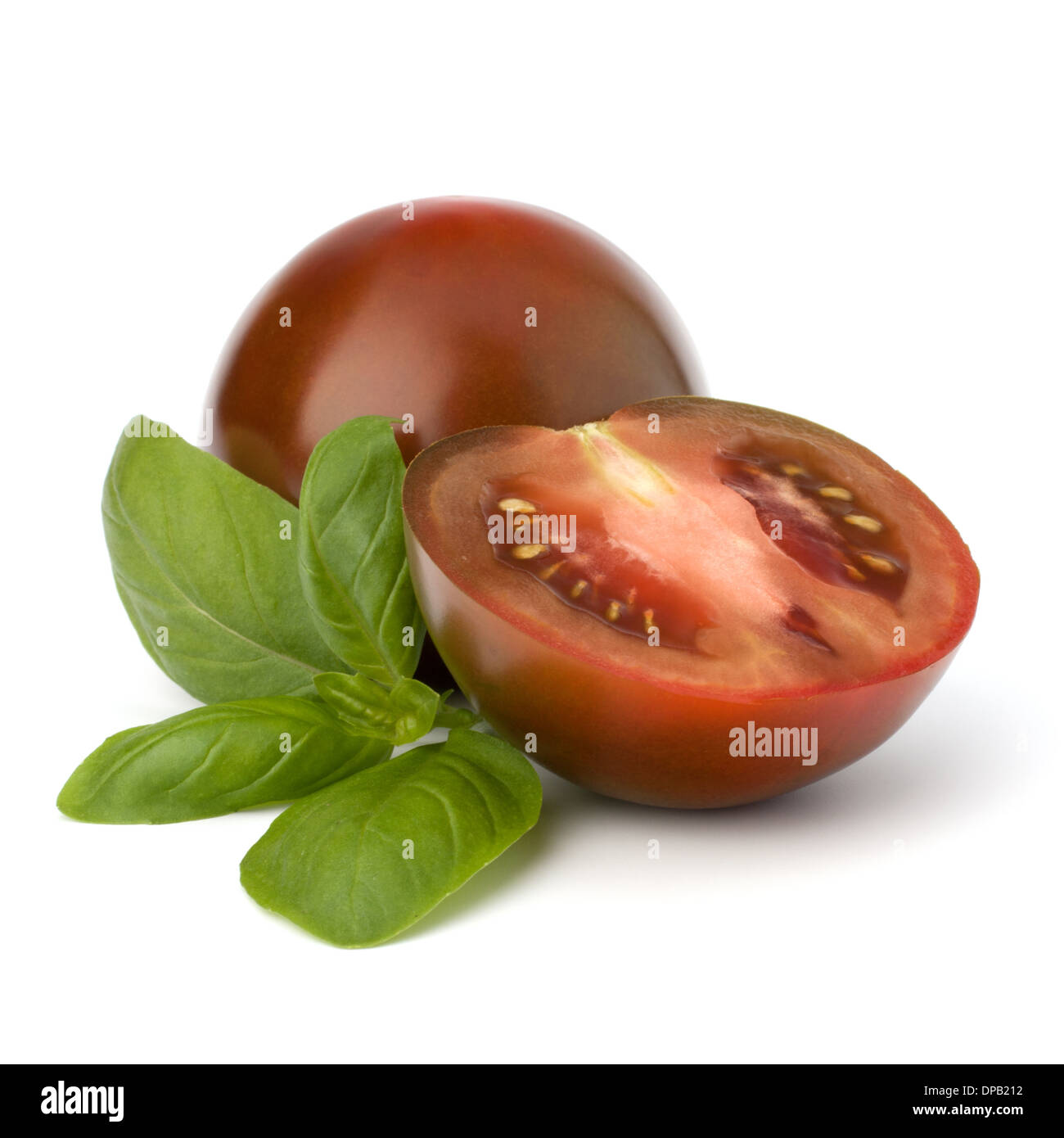 Tomato kumato and basil leaf isolated on white background Stock Photo