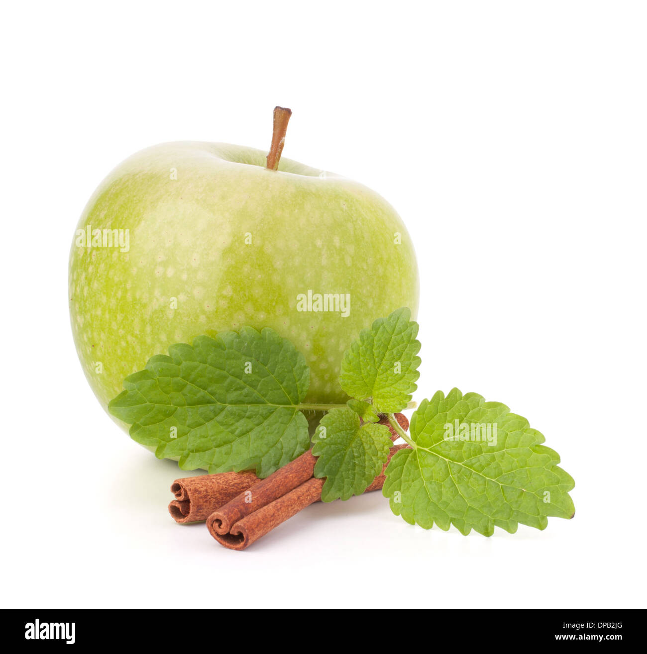 Green apple, cinnamon sticks and mint leaves still life isolated on white cutout. Stock Photo