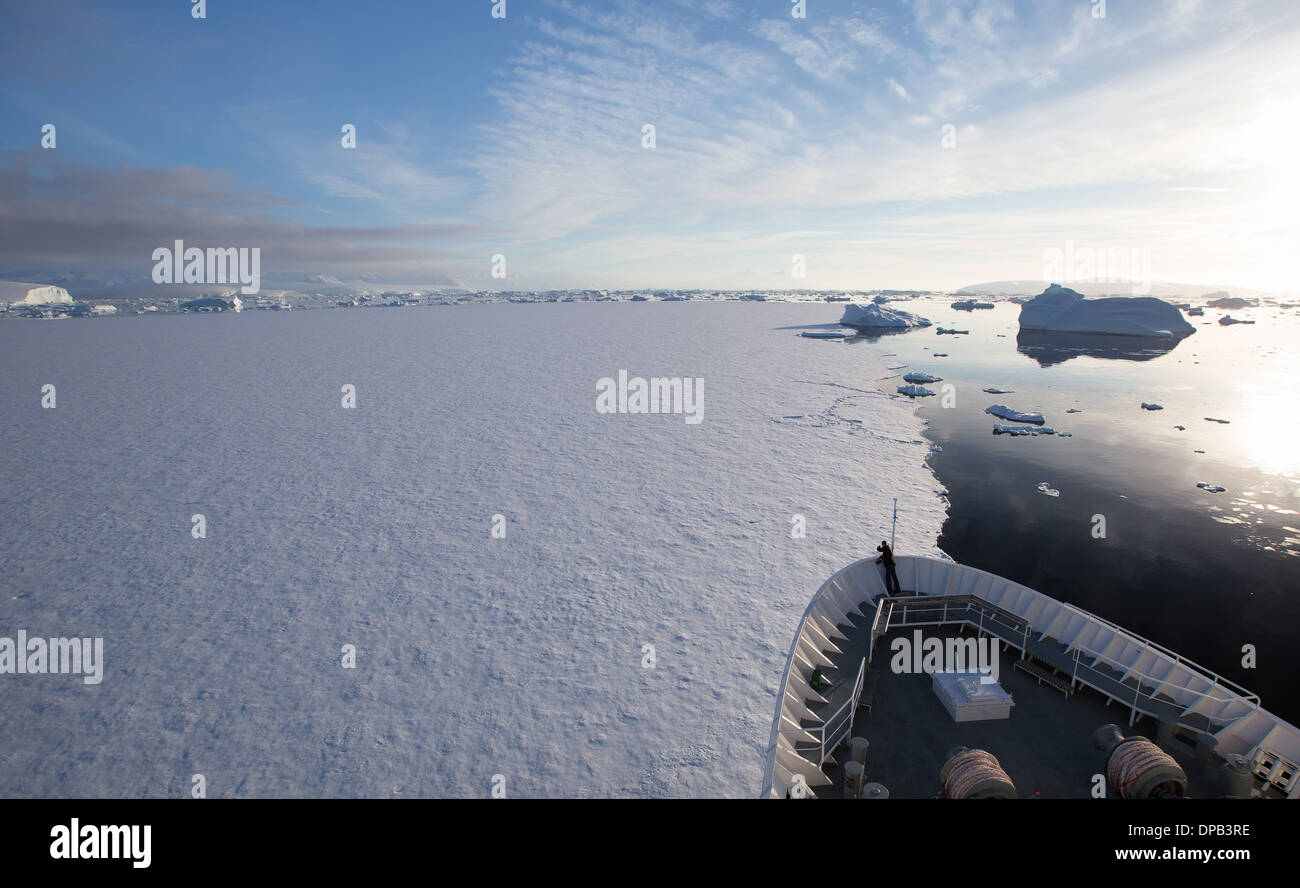 Cruise ship breaking through ice in Antarctica Stock Photo