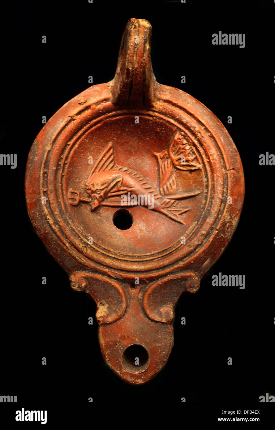 Symbols of the sea god Poseidon (The dolphin is the boon companions of the sailors) Oil Lamp 100 AD Roman Stock Photo