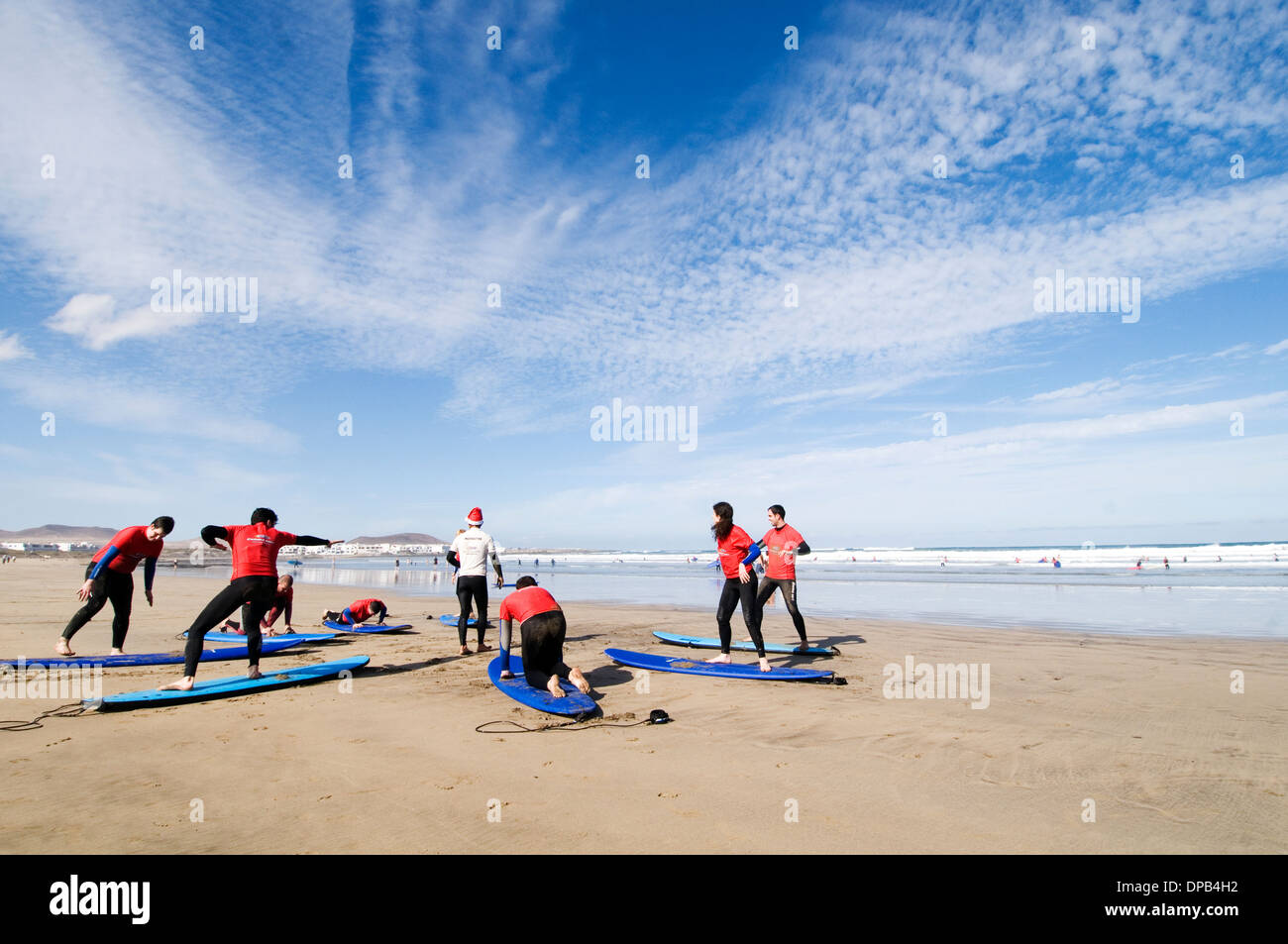 surfing lesson lessons learning to stand up on surf board boards surfboards beach playa famara lanzarote beach beaches canary is Stock Photo