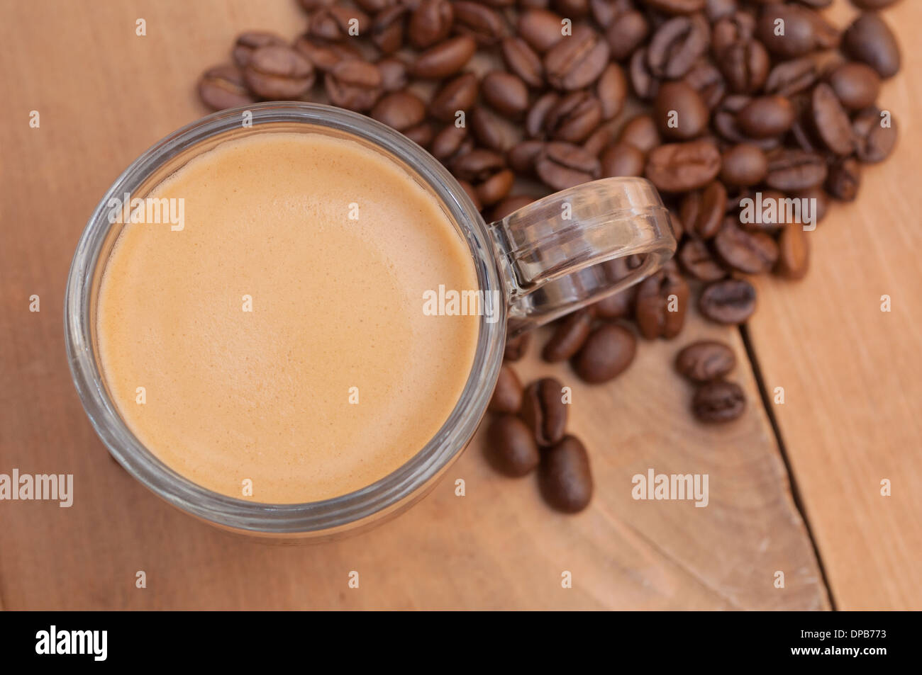 Top View of Glass Cup of Espresso Coffee on Wooden Table With Coffee Beans - Shallow Depth of Field Stock Photo
