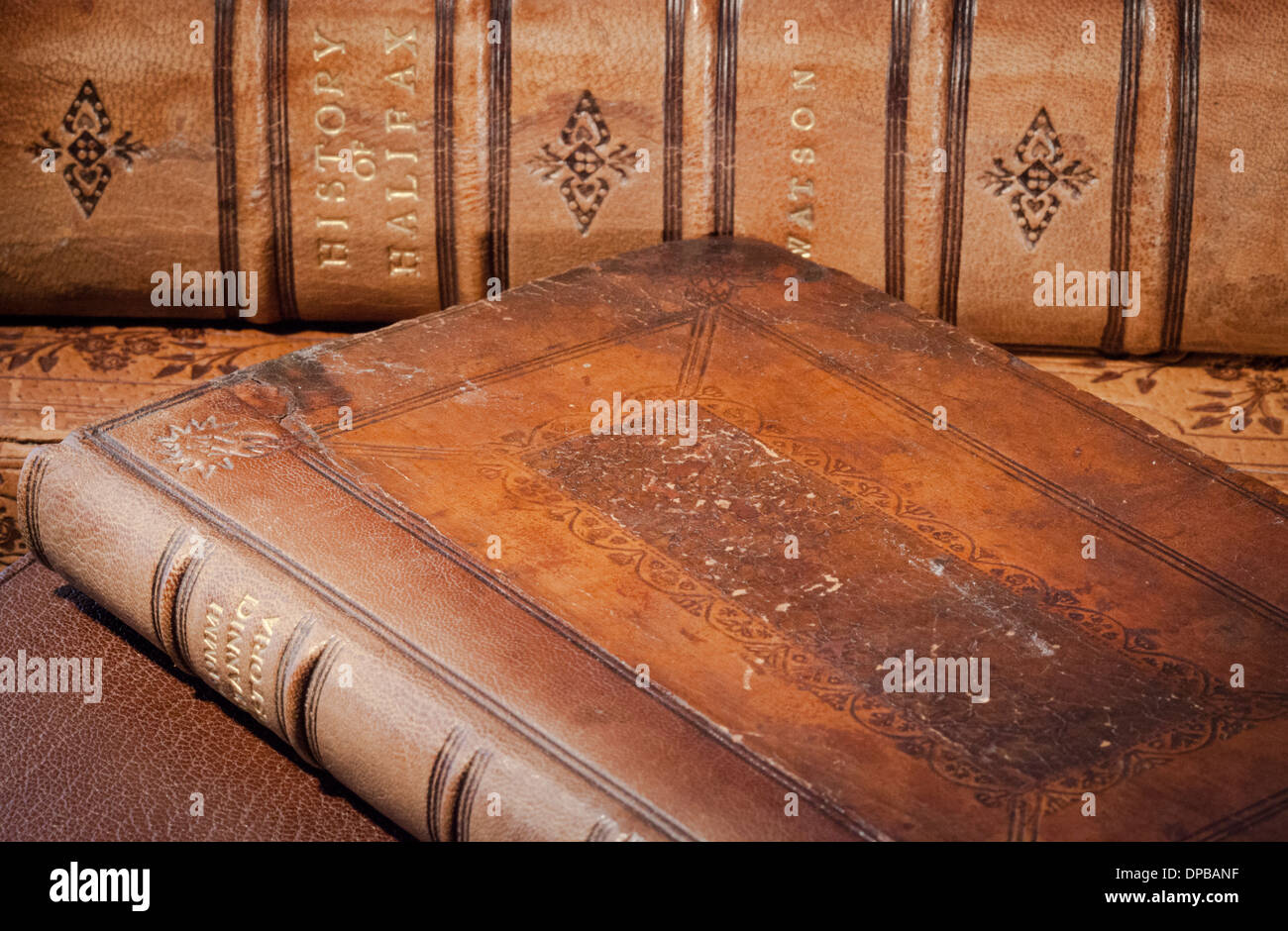 Old books in brown leather binding. Foreground volume shows clearly the