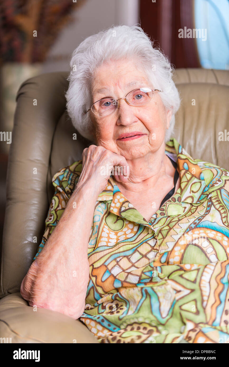 Aged woman sitting in an armchair Stock Photo - Alamy