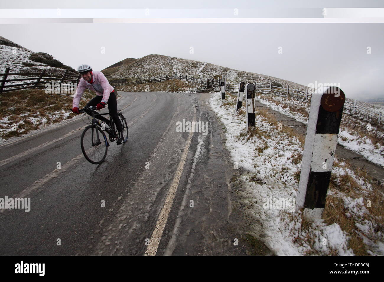 Peak District, Derbyshire, UK. 11th January 2014. 11 Jan 2014. Cyclists brave wintry conditions near Castleton after overnight snowfall hit high ground across stretches of Derbyshire's Peak District. Credit:  Matthew Taylor/Alamy Live News Stock Photo