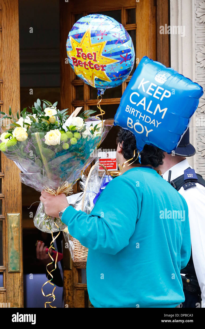 A man with flowers and balloon arrives to the London Clinic where the Duke of Edinburgh, Prince Philip is hospitalised in London Stock Photo