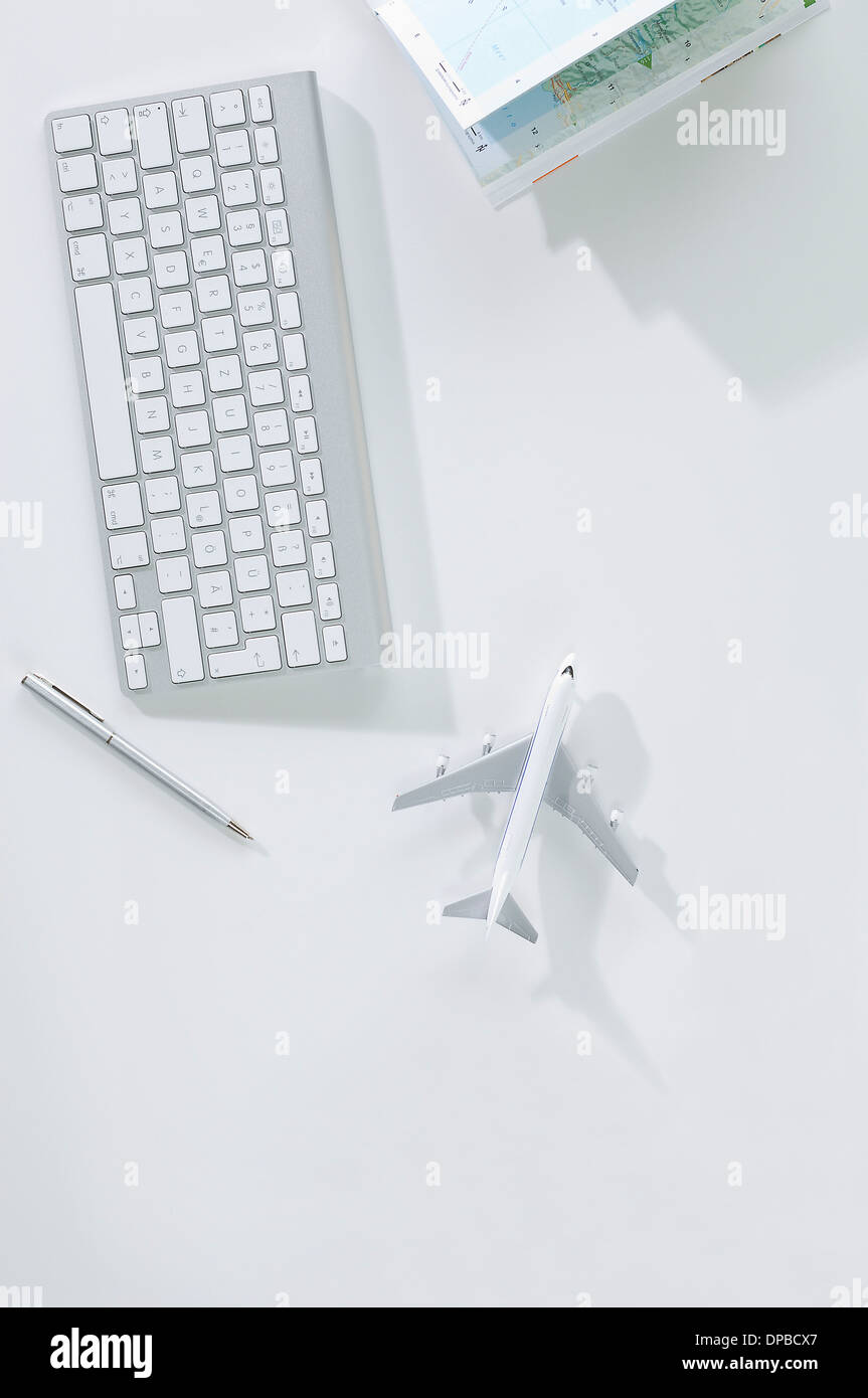 Keyboard, ball pen, map and airplane miniature Stock Photo