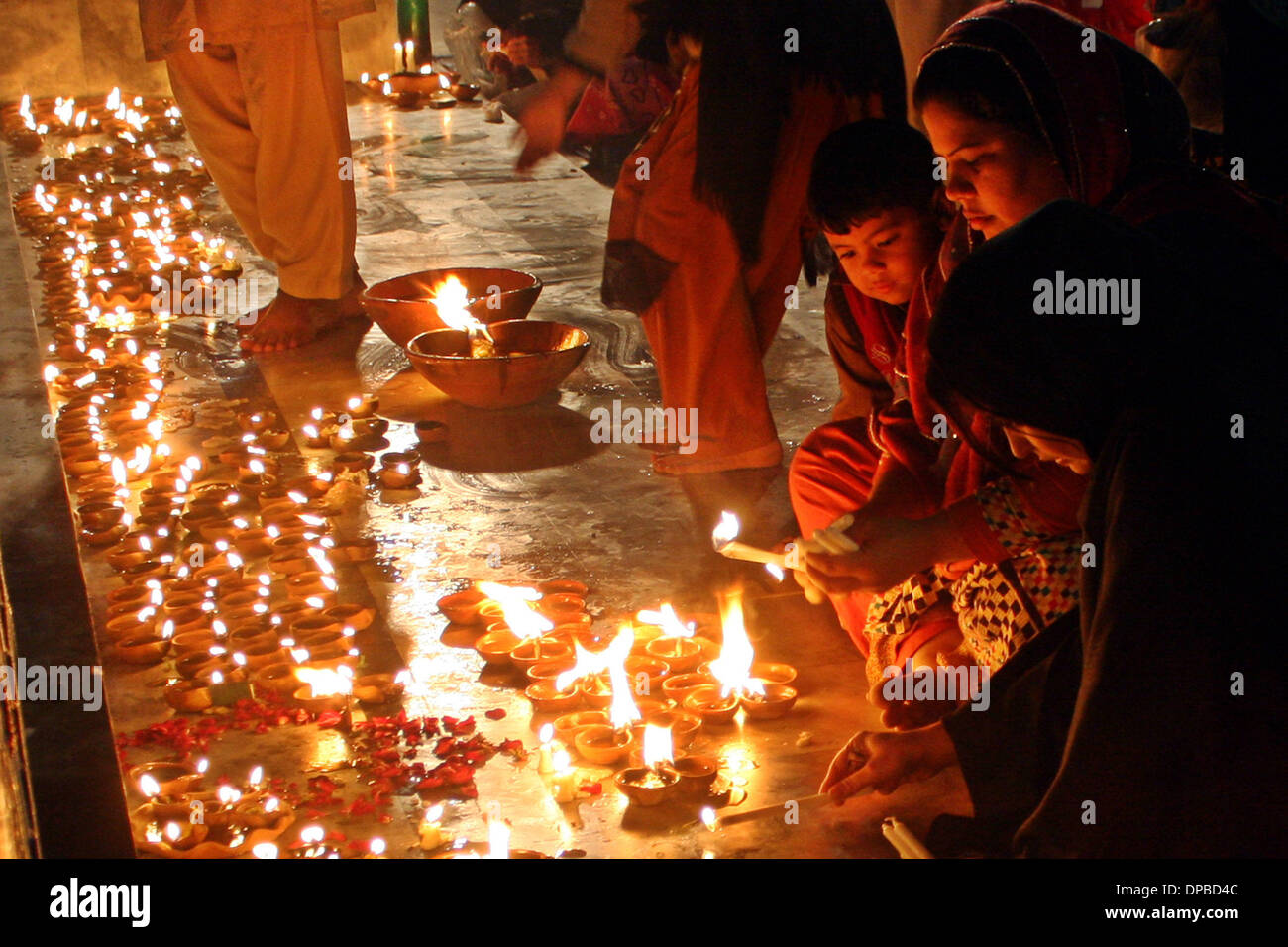 Lahore, Pakistan. 11th Jan, 2014. Pakistani Muslim devotees light oil lamps at the shrine of the Sufi saint Mian Mir Sahib during the last day of a three-day festival marking his 369th death anniversary in eastern Pakistan's Lahore on Jan. 11, 2014. Credit:  Jamil Ahmed/Xinhua/Alamy Live News Stock Photo