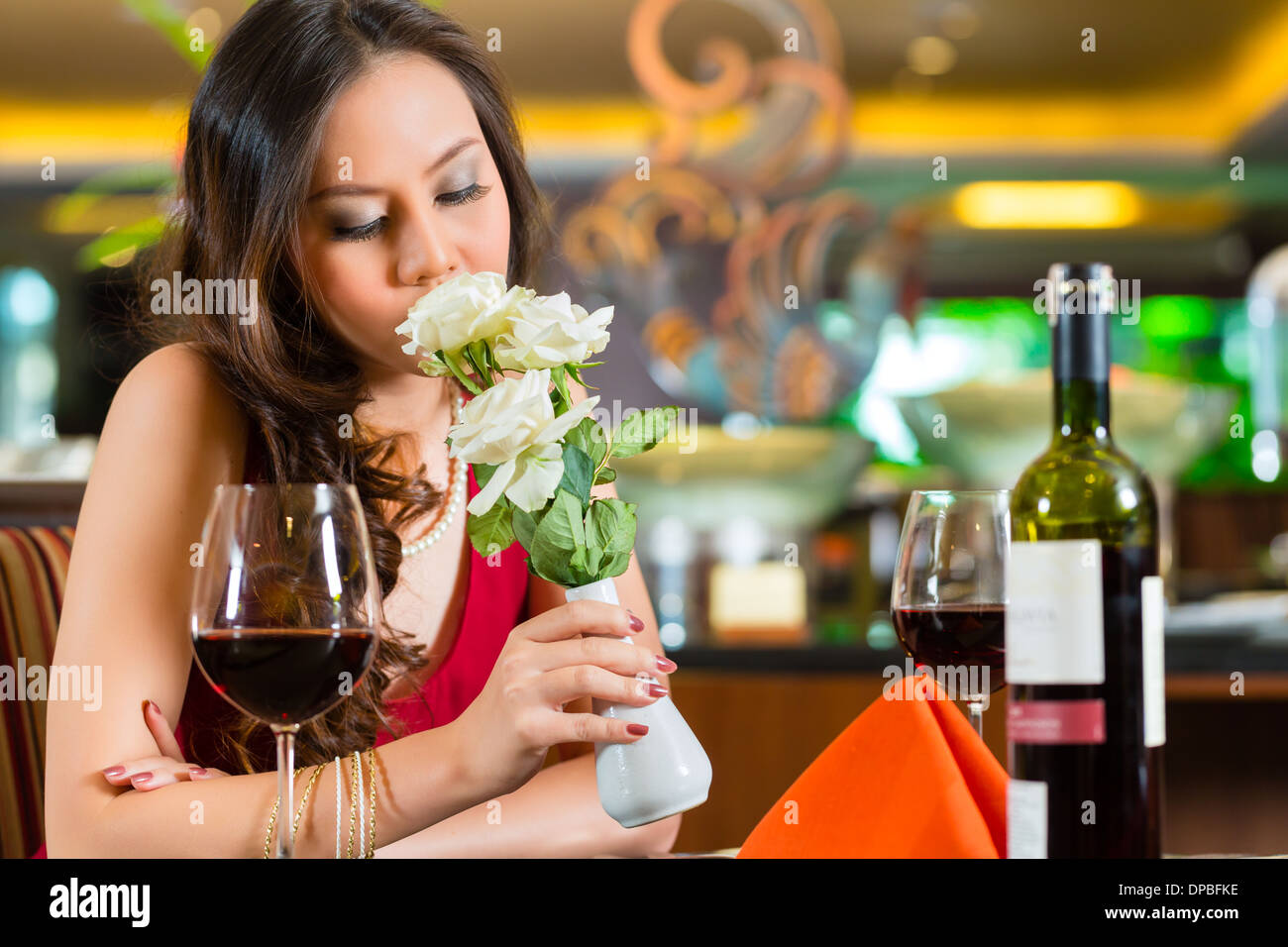 Chinese nervous, hoping, lonely, dreamy, heartsick woman in a restaurant waiting for a date got stood up Stock Photo