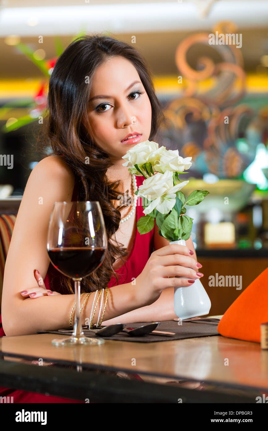 Chinese nervous, hoping, lonely, dreamy, heartsick woman in a restaurant waiting for a date got stood up Stock Photo