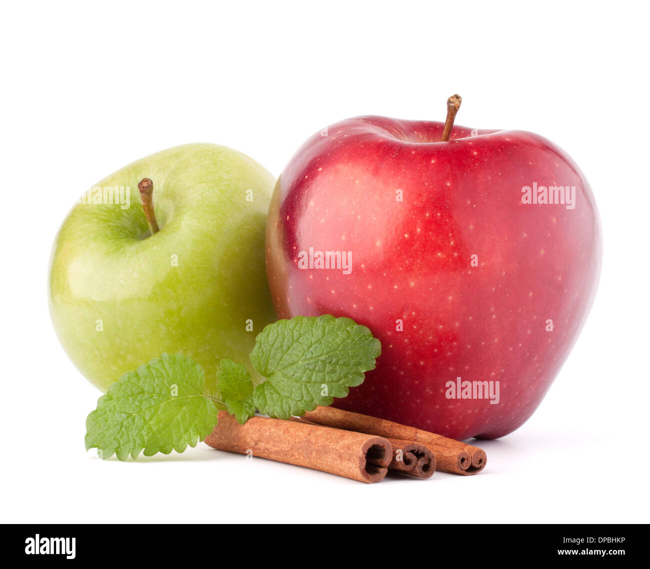 Red and green apples, cinnamon sticks and mint leaves still life isolated on white cutout Stock Photo