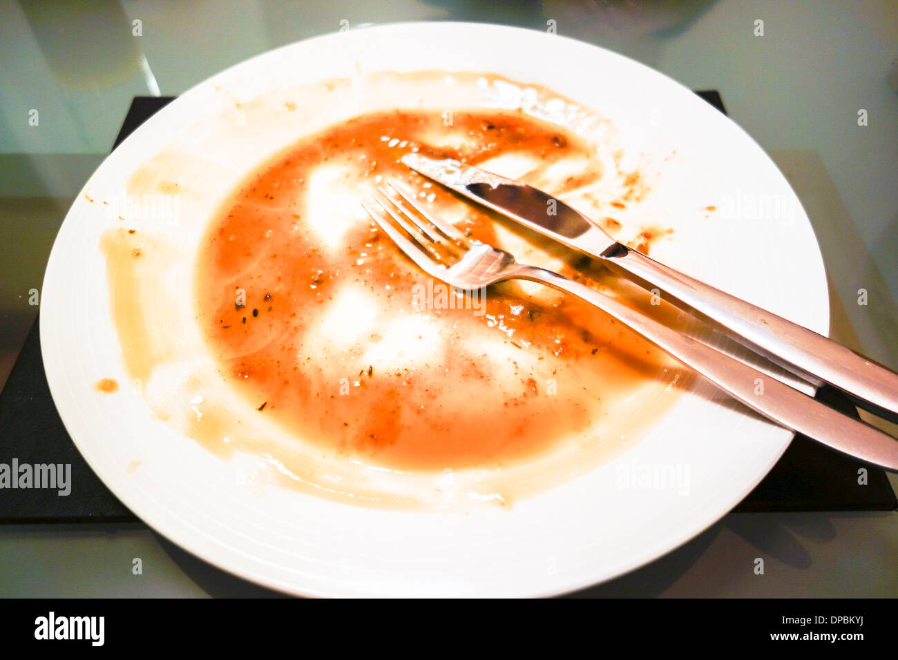 Empty plate from a just finished meal covered with food residue Stock Photo