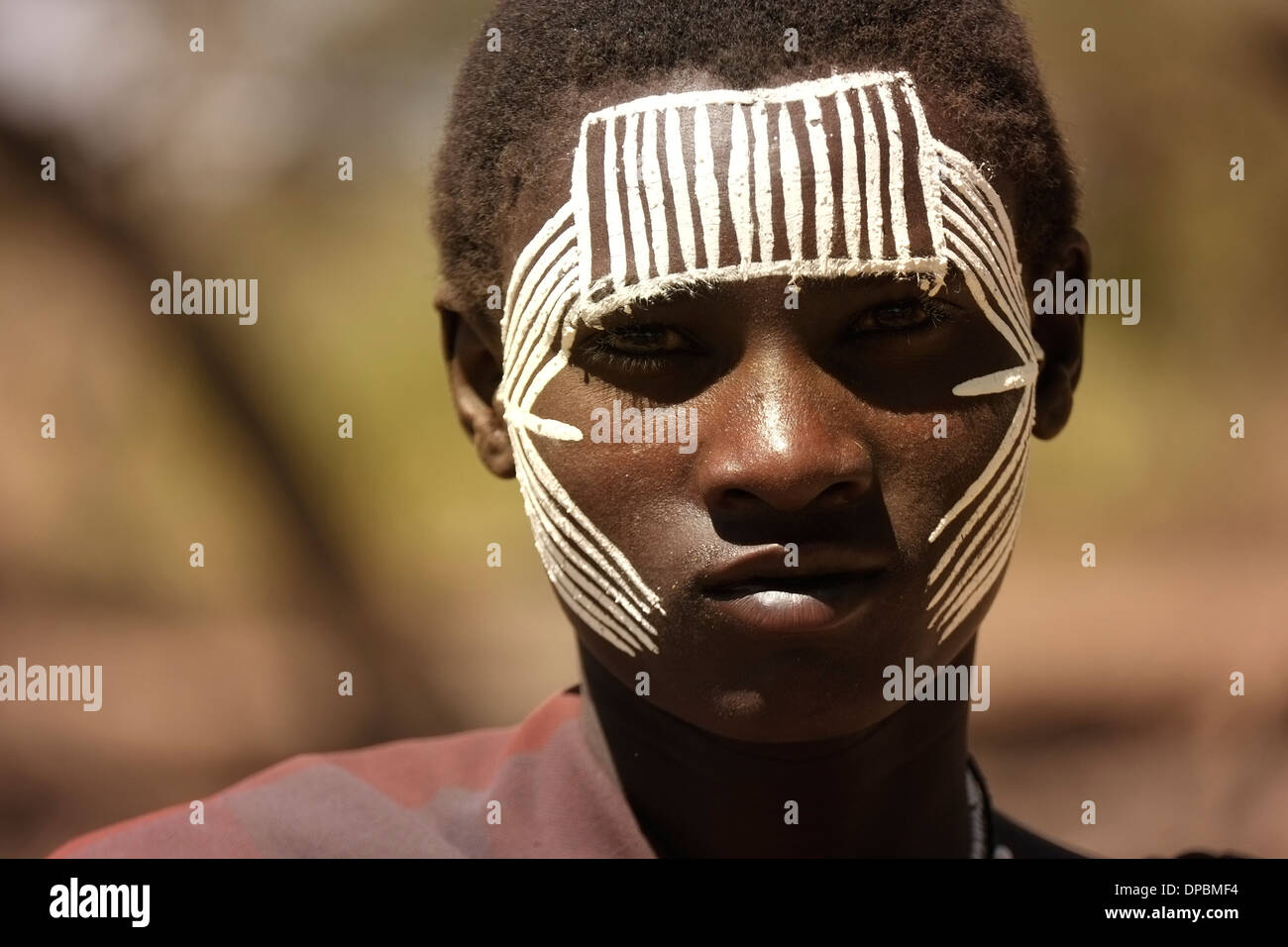 A teenage Maasai with painted face after the 'emorata' ceremony, which is the circumcision and right of passage to become a member of the warrior or 'moran' class in the Ngorongoro Conservation Area Tanzania Eastern Africa Stock Photo