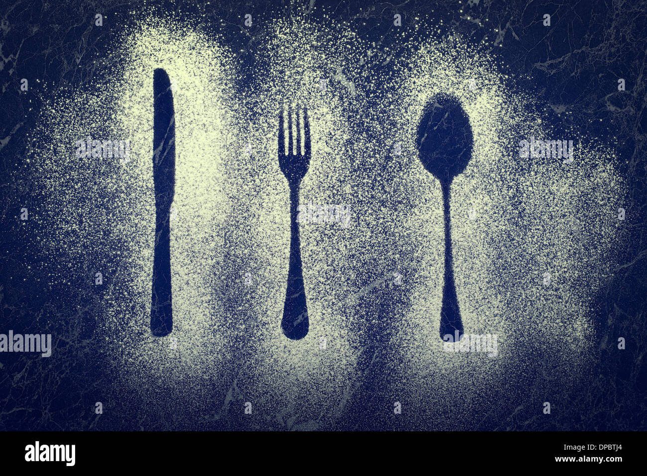 Outlines of knife, fork and spoon made with a dusting of icing sugar Stock Photo