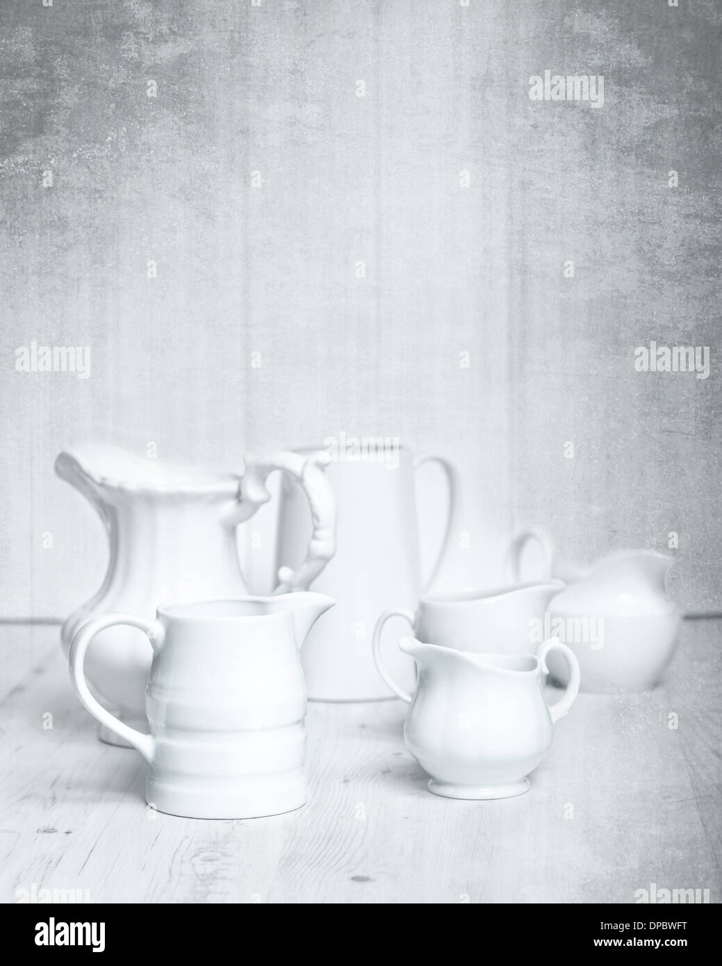 Collection of white jugs on rustic grungy background Stock Photo