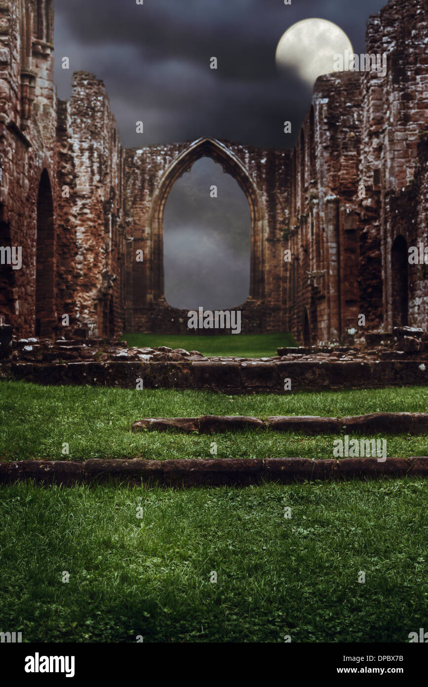 Steps leading to the ruins of an abbey at night with dark brooding sky Stock Photo