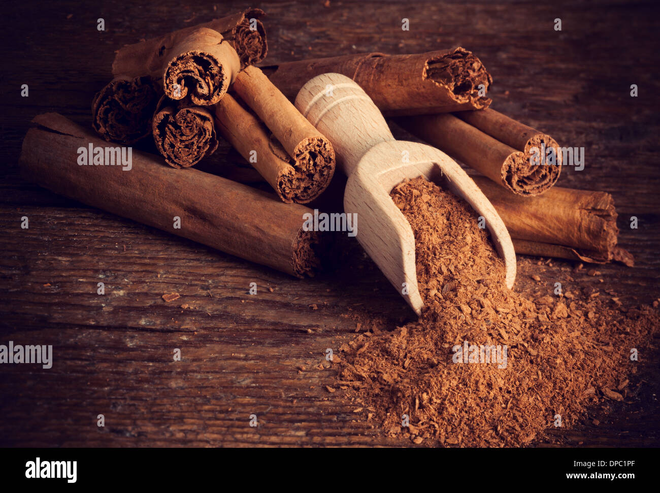 Sticks and ground ceylon cinnamon with wood spoon on wooden table Stock Photo