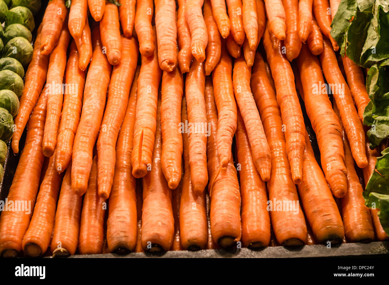 Bulk display of orange carrots at a produce vendor market stall.  Pike Place Market, Seattle, Washington, USA Stock Photo