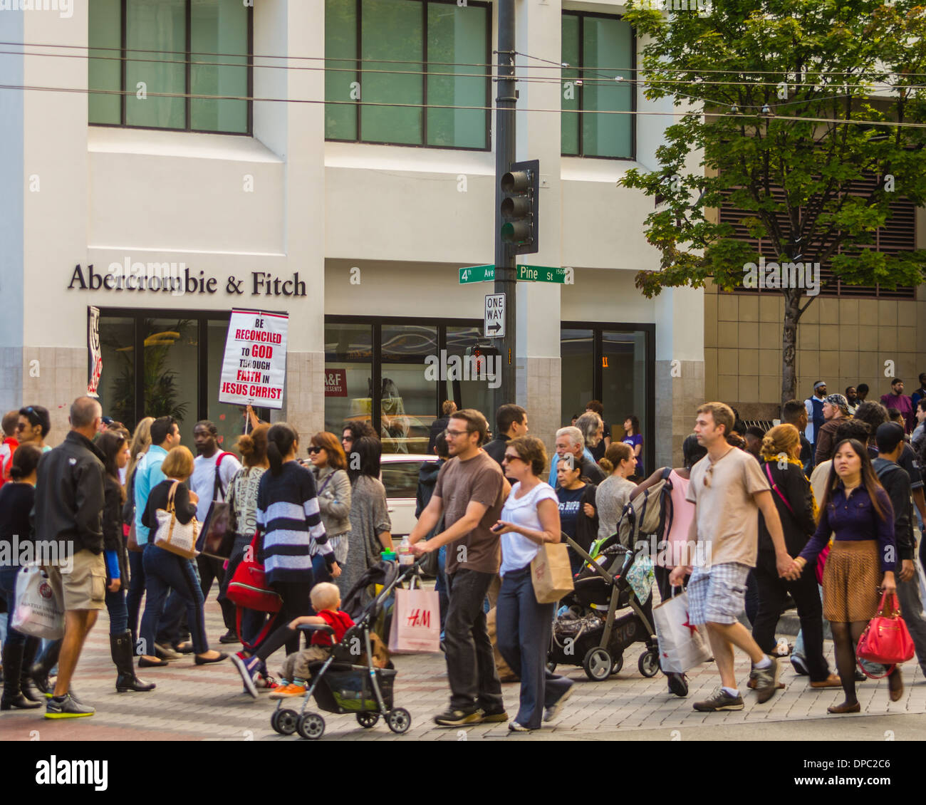 Shoppers walking past a street evangelist outside down town Abercrombie & Fitch store.  Seattle, Washington, USA Stock Photo
