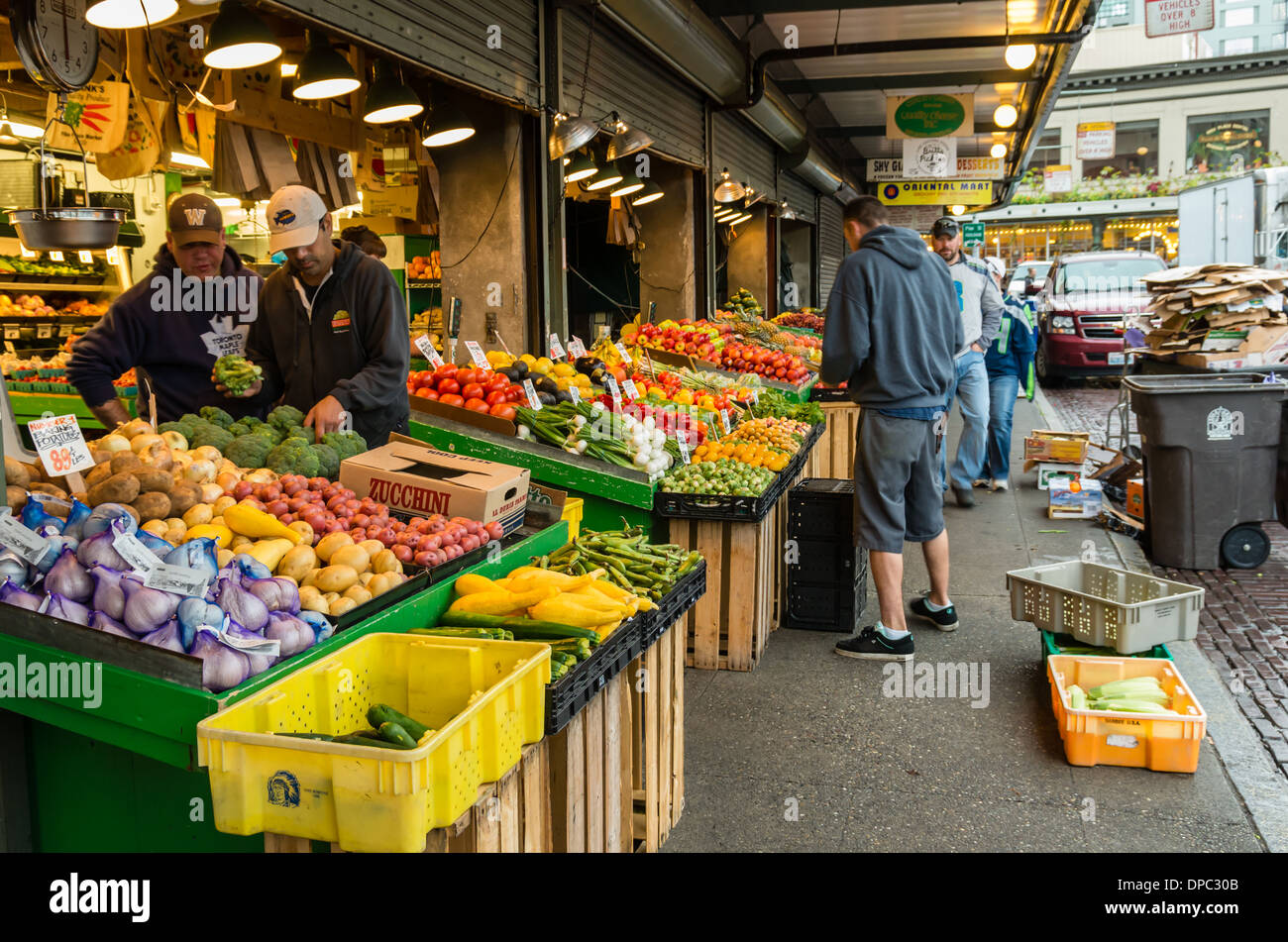 Shoppers selecting fruits and vegetables at an open air market stall. Pike Place Market, Seattle, Washington Stock Photo