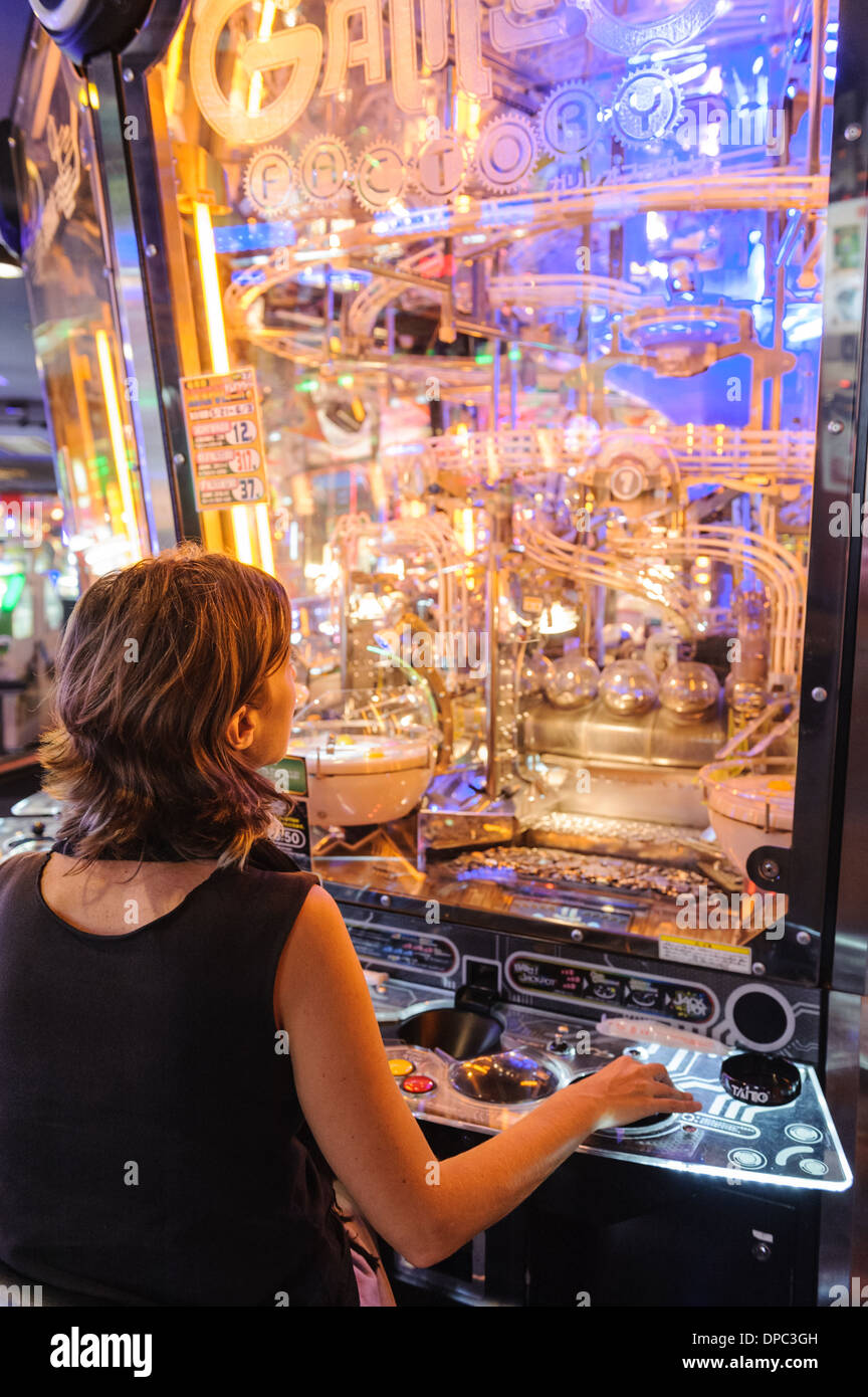 Woman gambling at a slot machine, Hiroshima, Japan, Asia. Stock Photo