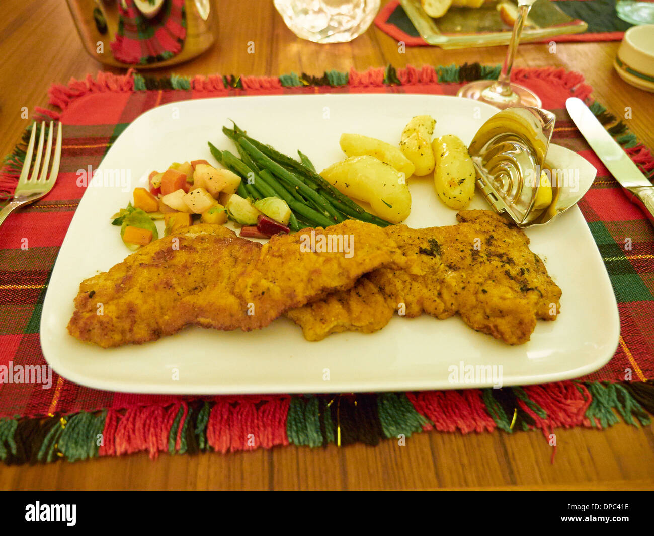 Wiener schnitzel with winter vegetables, green beans, and buttered boiled potatoes Stock Photo