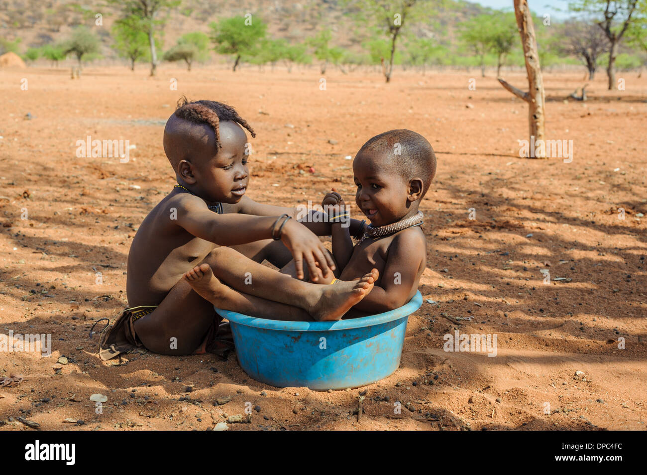 Himba children playing on the floor, Kunene region, Namibia, Africa Stock Photo