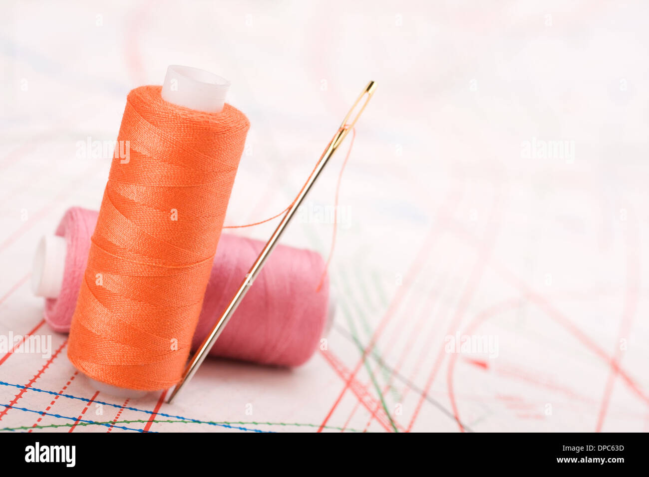 Spool of thread and needle. Sew accessories on blurred background Stock ...