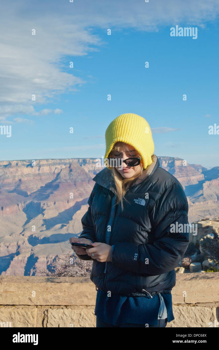 A young tourist at the Grand Canyon finds importance in a text message. Stock Photo