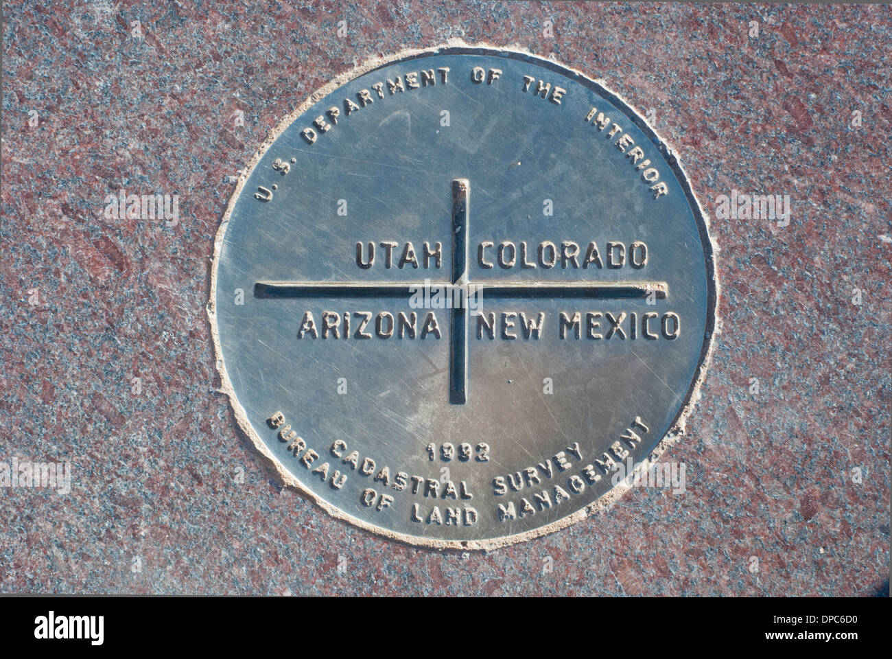 This marker denotes the spot where four states share the same corner.  It is called Four Corners and is located in four states. Stock Photo