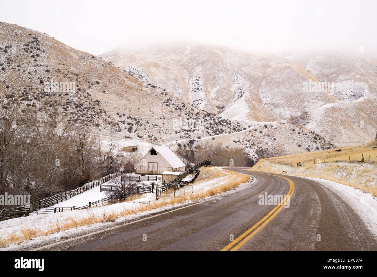 An icy road leads through country scene farm ranch hillside highway 71 Stock Photo