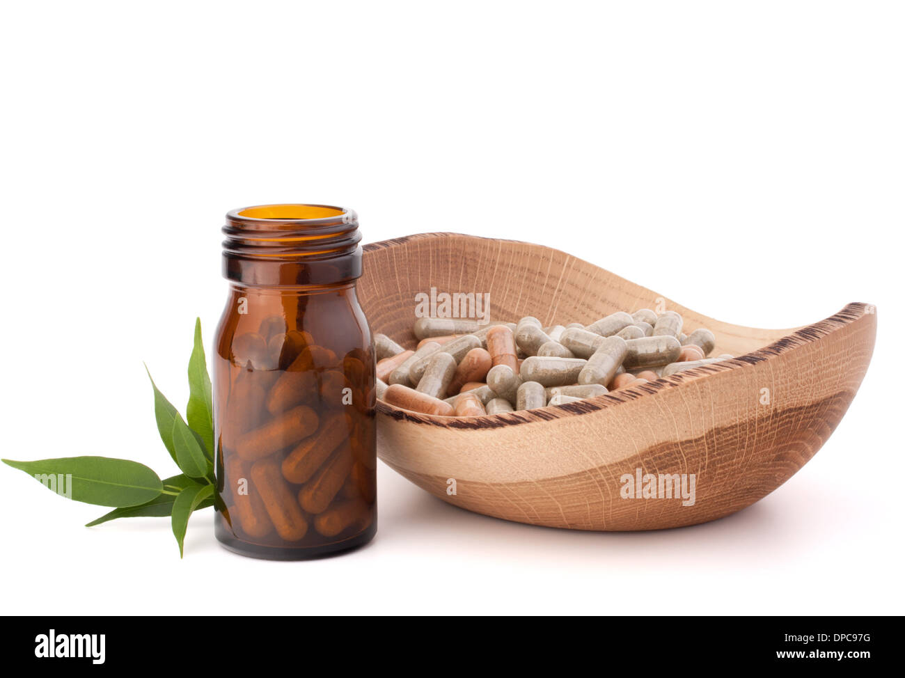 Herbal drug capsules in brown glass bottle isolated on white background
