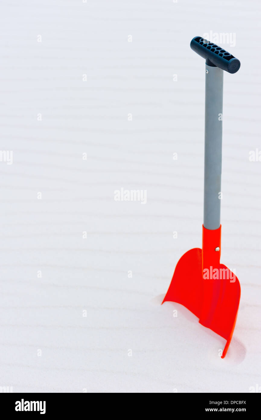 Vertical shot of an orange shovel in the sand Stock Photo