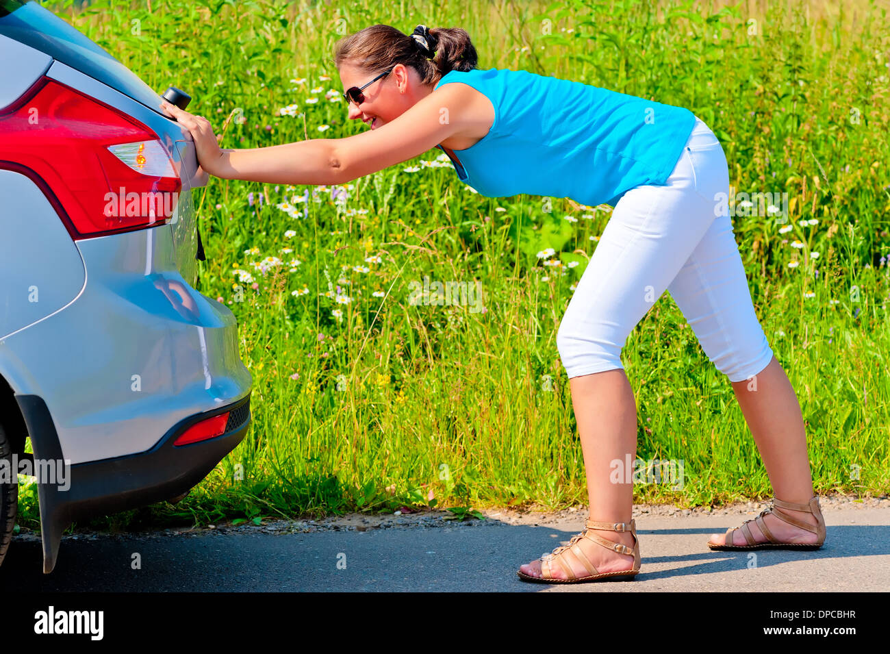 woman pushing car out of gasoline Stock Photo