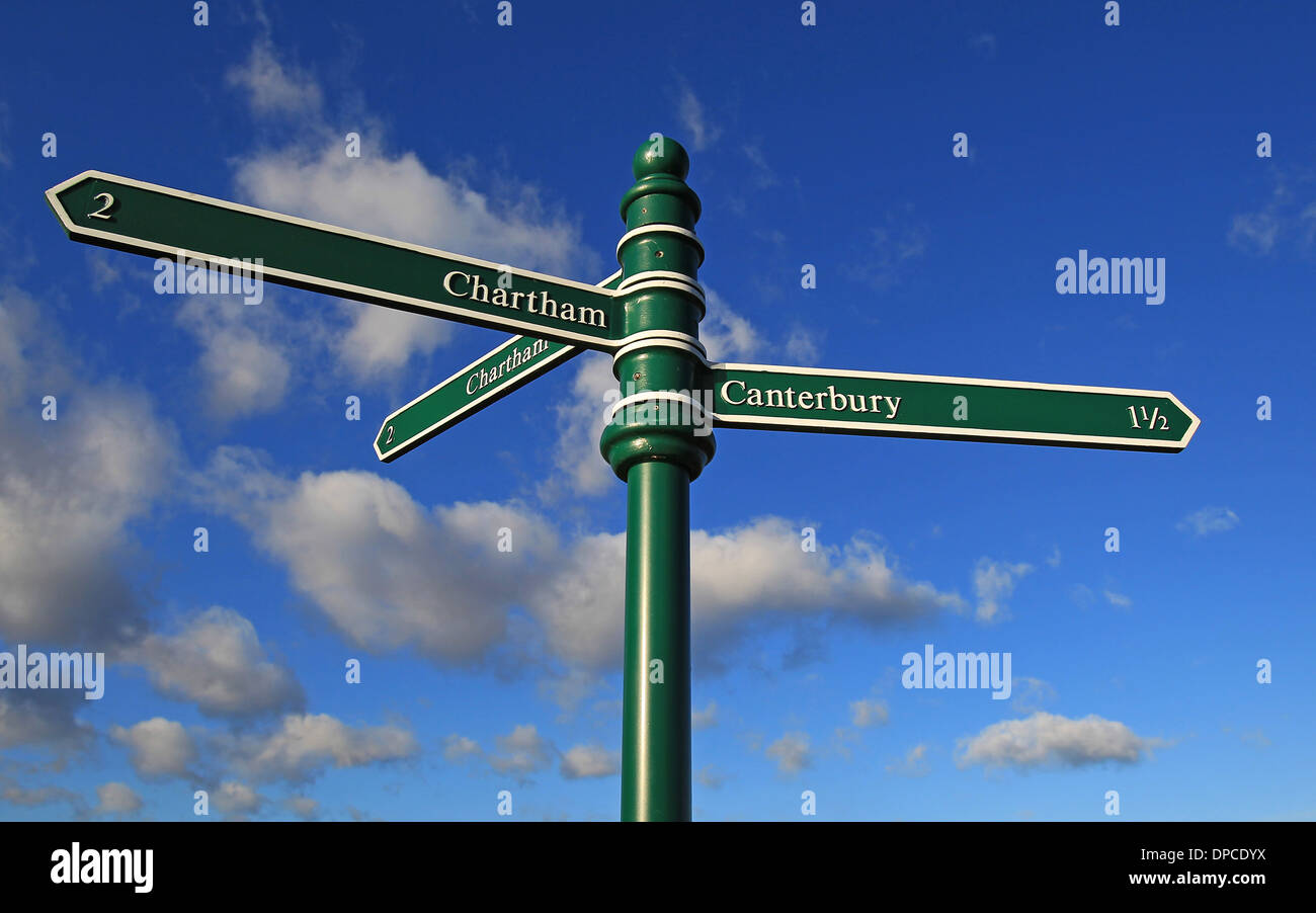 A green signpost with white lettering set against a blue sky with ...