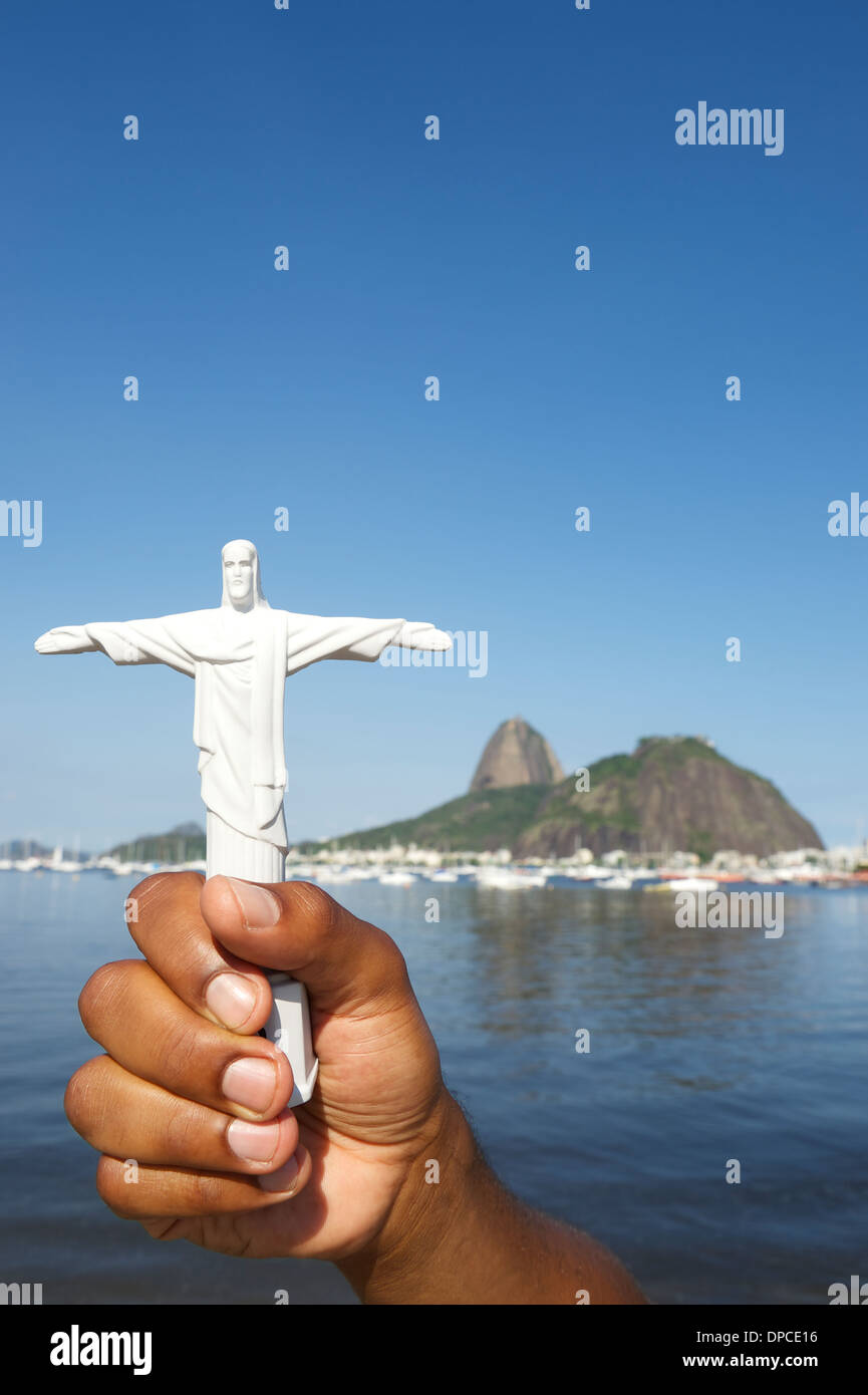 Brazilian holding Corcovado Christ the Redeemer statue souvenir at sunny view Sugarloaf Mountain Rio de Janeiro skyline Brazi Stock Photo