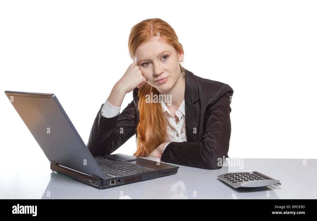 Young well dressed red haired Girl is sitting frustrated in front of the computer Stock Photo