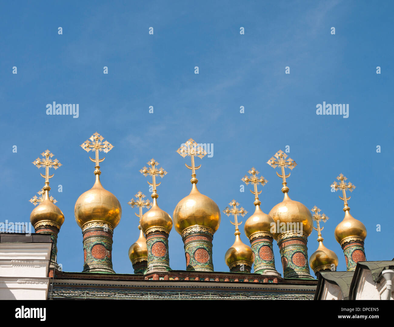 The Kremlin, Moscow Russia, detail, numerous small gilded onion domes with coloured base and crosses against blue sky Stock Photo