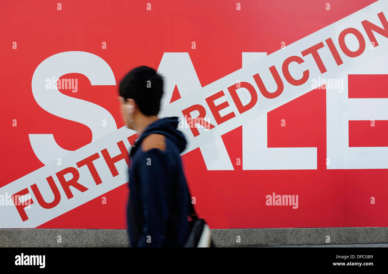 A man walks past the Sale sign outside a shop Stock Photo
