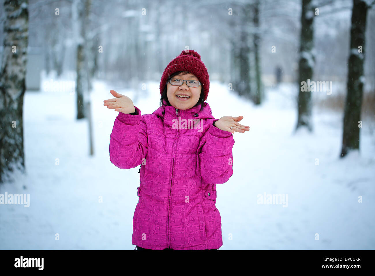 Young and happy asian girl with a pink jacket enjoys snowing Stock Photo