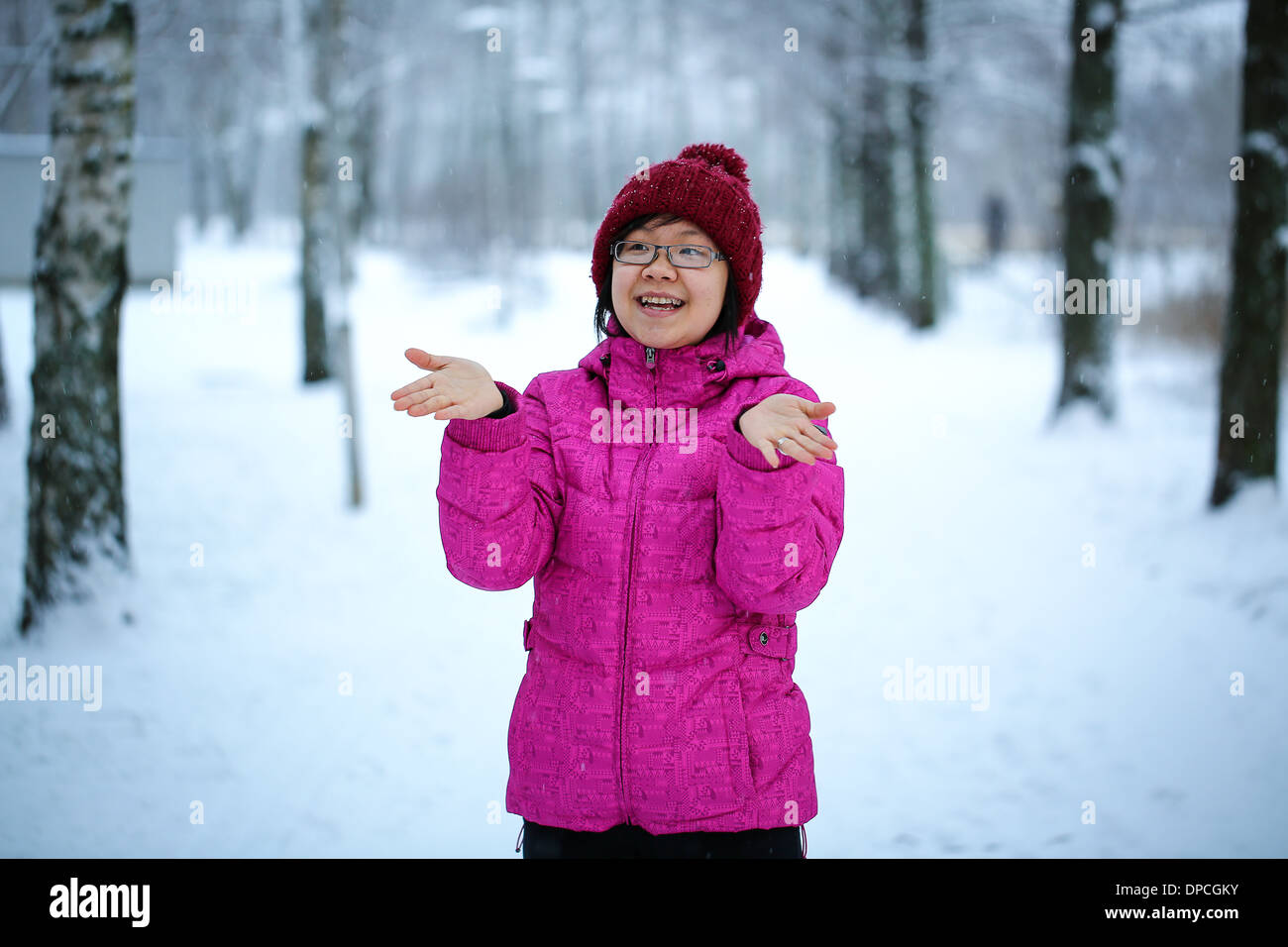 Young and happy asian girl with a pink jacket enjoys snowing Stock Photo