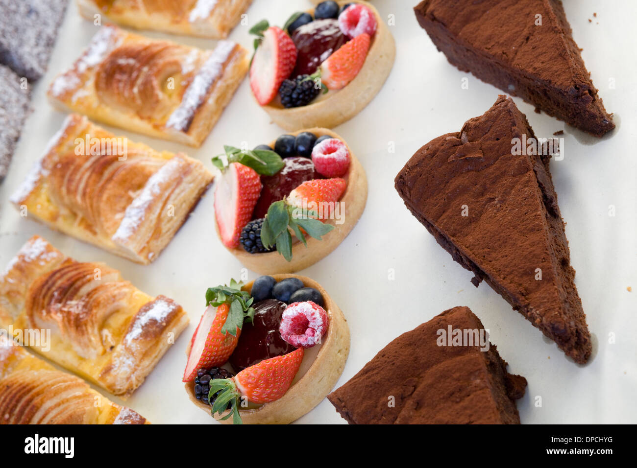 Pastries Tarts and Brownies Cakes for sale on White Table Cloth Stock