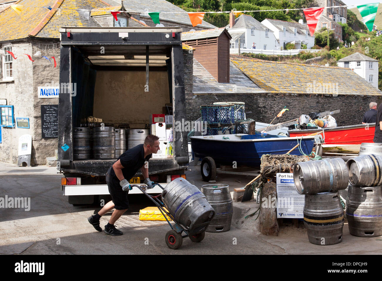 A brewery drayman delivering beer kegs to a public house in Cornwall, U.K. Stock Photo